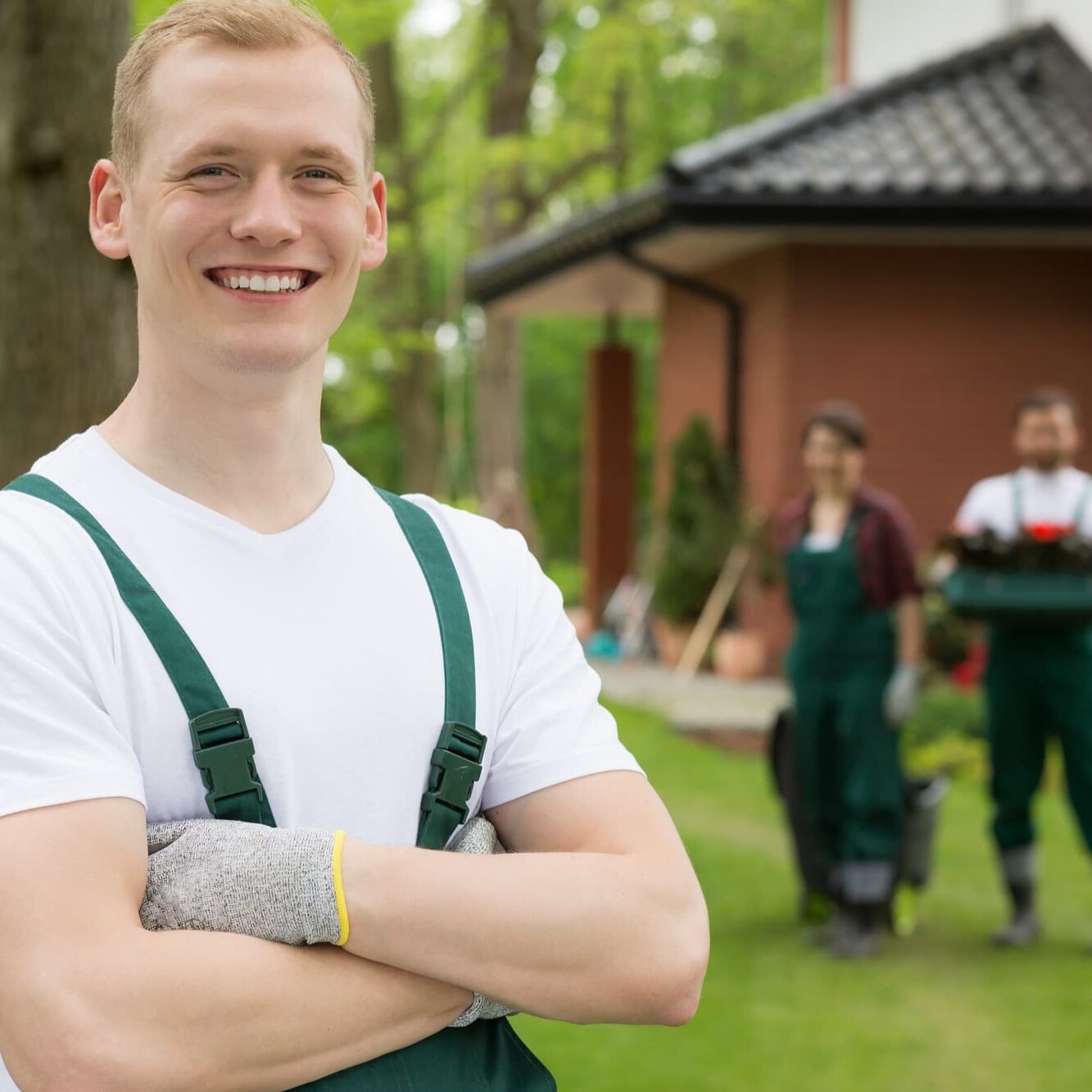 Portrait of a red-haired gardener in protective gloves, smiling